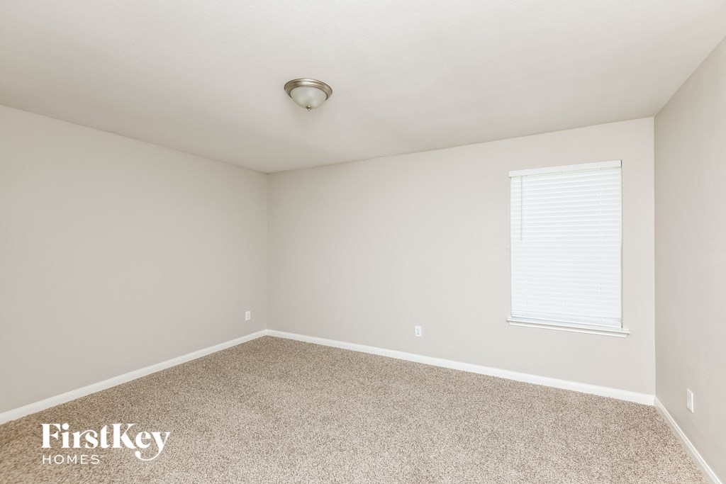 a bedroom with a carpeted floor and a window