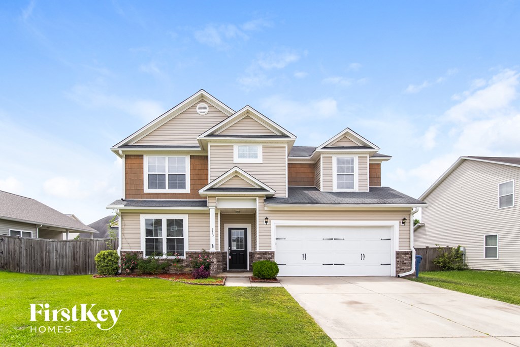A large, two-story house with a garage is showcased in the image.