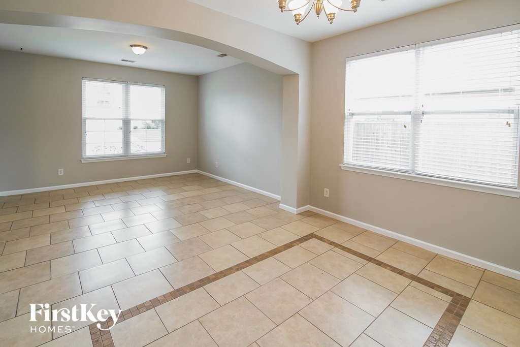 A spacious room with a tiled floor and a chandelier.