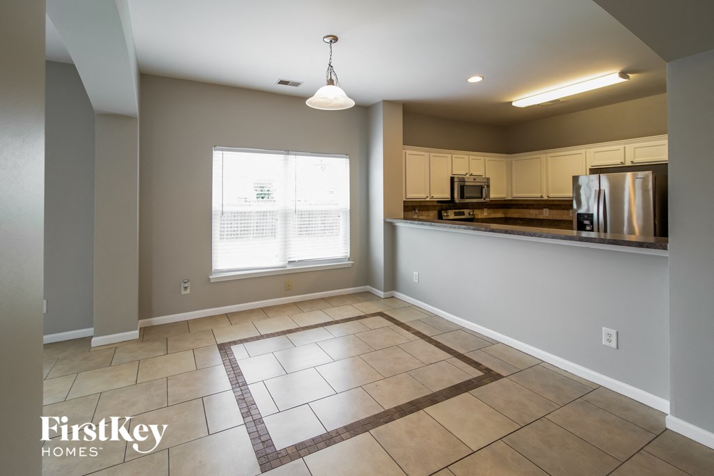A kitchen area with a tile floor and a window.