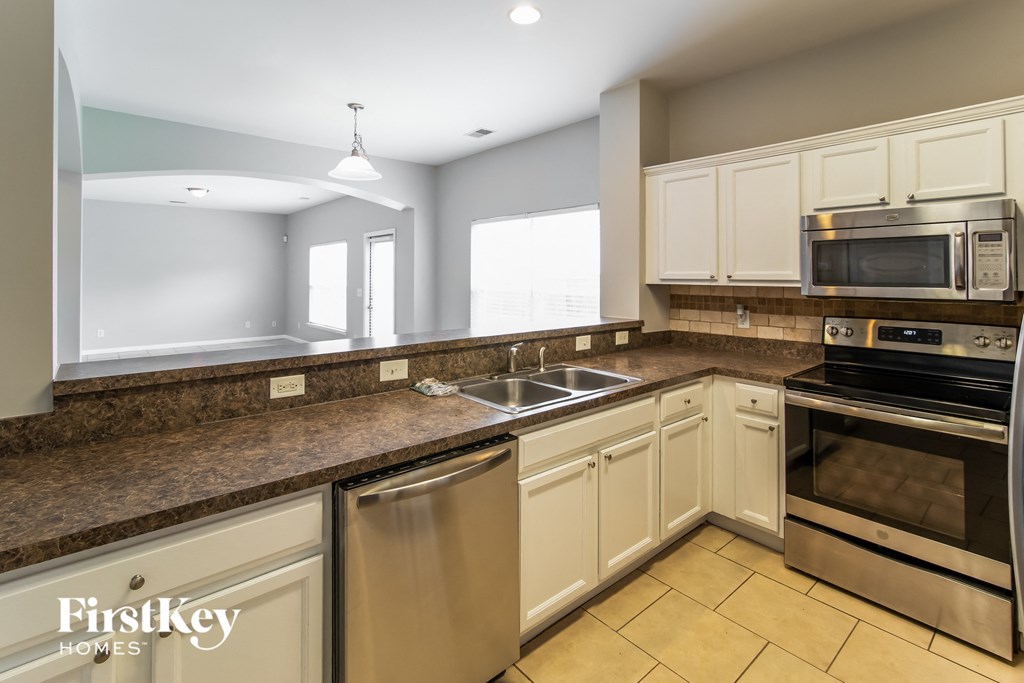 A kitchen with a stainless steel dishwasher and oven.