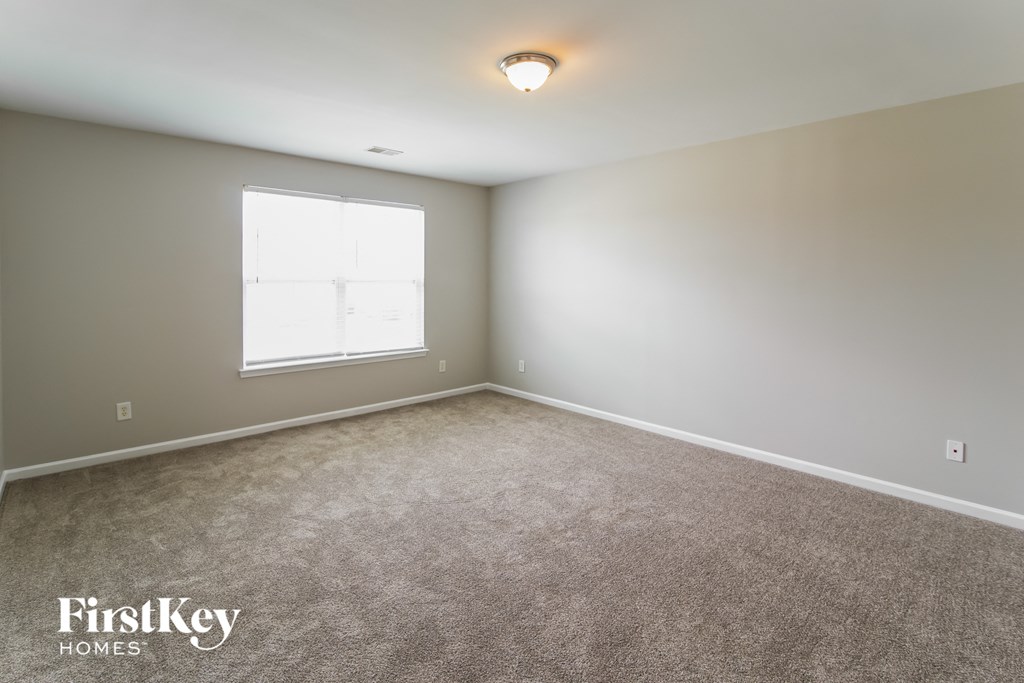 A room with a carpeted floor and a window.