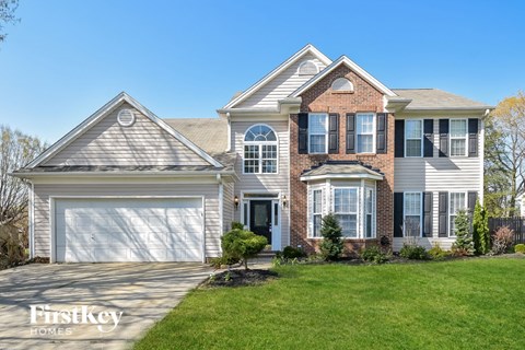 a large house with a garage door and a lawn