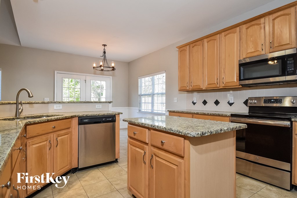 a kitchen with granite counter tops and wooden cabinets
