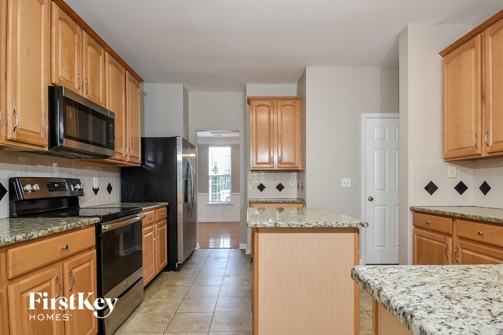 a kitchen with wooden cabinets and black appliances and granite counter tops