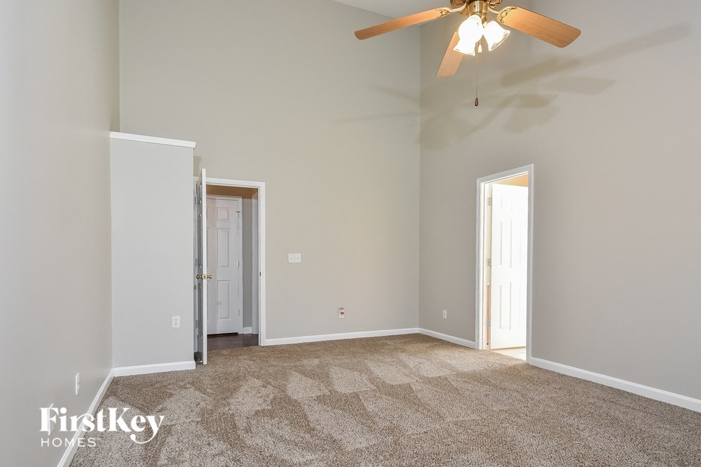 a living room with carpet and a ceiling fan