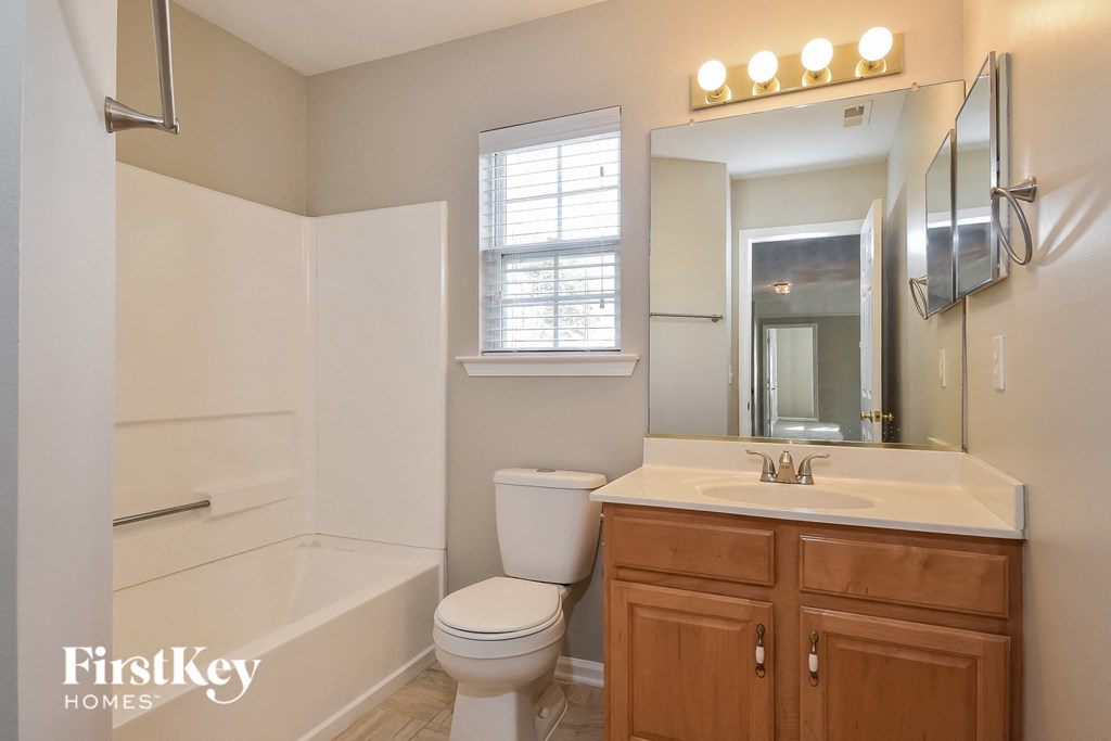 a bathroom with a toilet and a sink and a bath tub