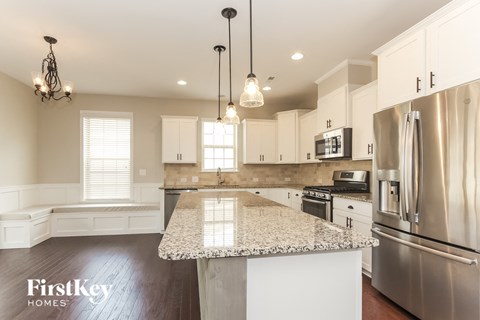 A kitchen with a granite countertop and stainless steel appliances.