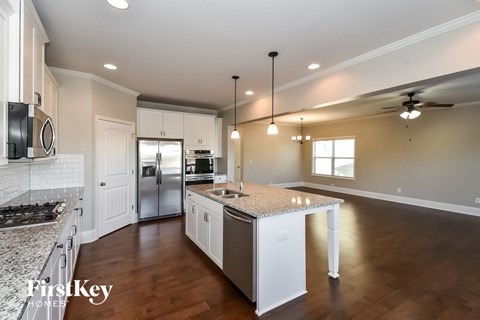 A kitchen with a granite countertop and a white fridge.