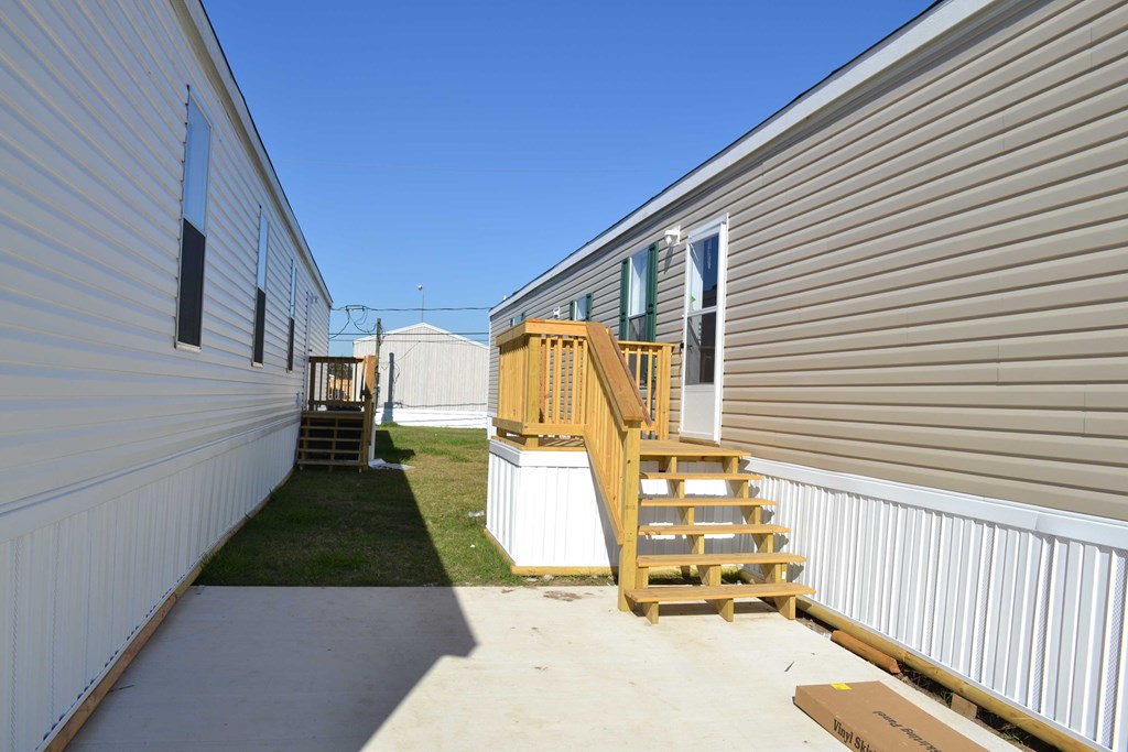 the backyard of a mobile home with stairs and a porch