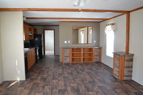 an open living room with a kitchen and a wood floor