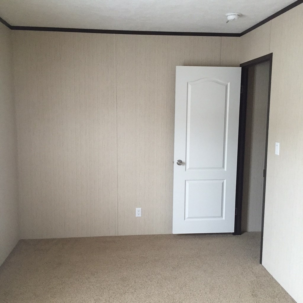 an empty room with a white door and a closet