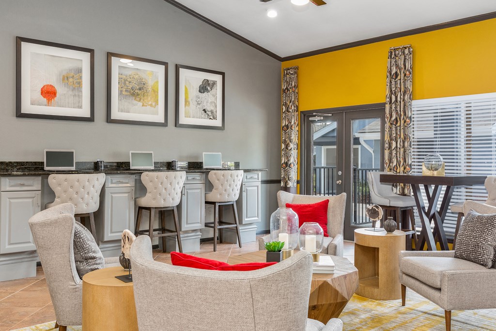 a living room with yellow walls and a bar with chairs and tables
