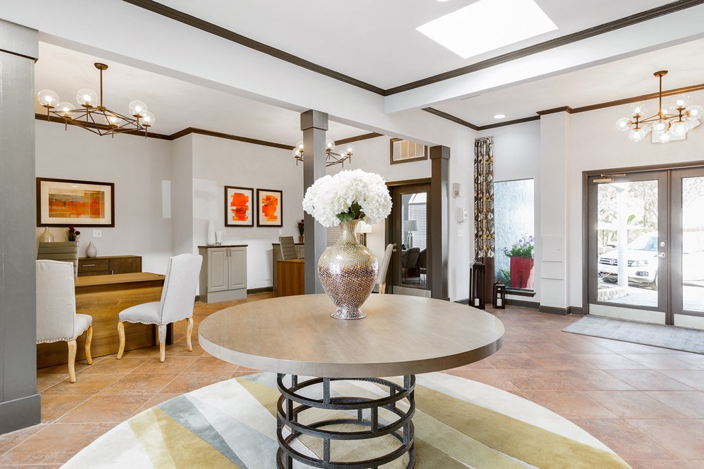 a living room with a table and a vase with flowers