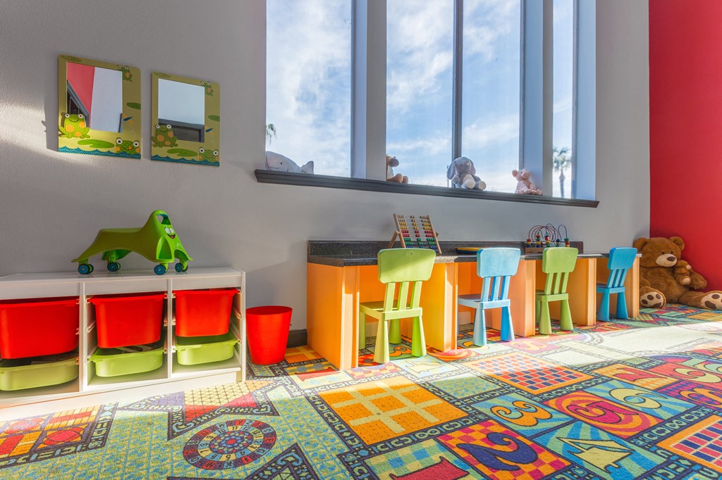 a childs play room with a table and chairs and a window
