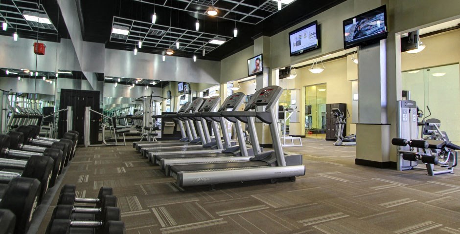 Luxury apartments with huge fitness center with multiple varieties of workout equipment, free weights, yoga and spin rooms at The Lanesborough Apartments in Houston