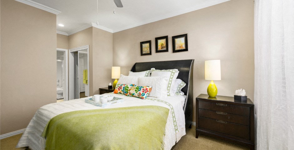 Spacious bedroom with walk-in closet and ceiling fan at The Lanesborough Apartments in Houston.