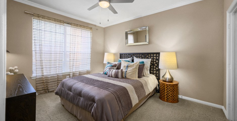 Spacious bedroom with walk-in closet and ceiling fan at The Lanesborough Apartments in Houston.