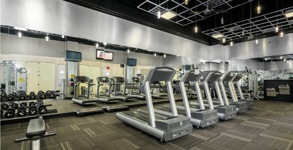 Luxury apartments with huge fitness center with multiple varieties of workout equipment, free weights, yoga and spin rooms at The Lanesborough Apartments in Houston.