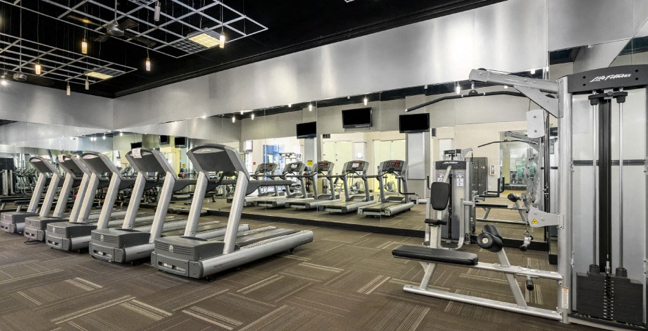 Luxury apartments with huge fitness center with multiple varieties of workout equipment, free weights, yoga and spin rooms at The Lanesborough Apartments in Houston.