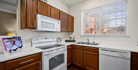 a kitchen with white appliances and wooden cabinets