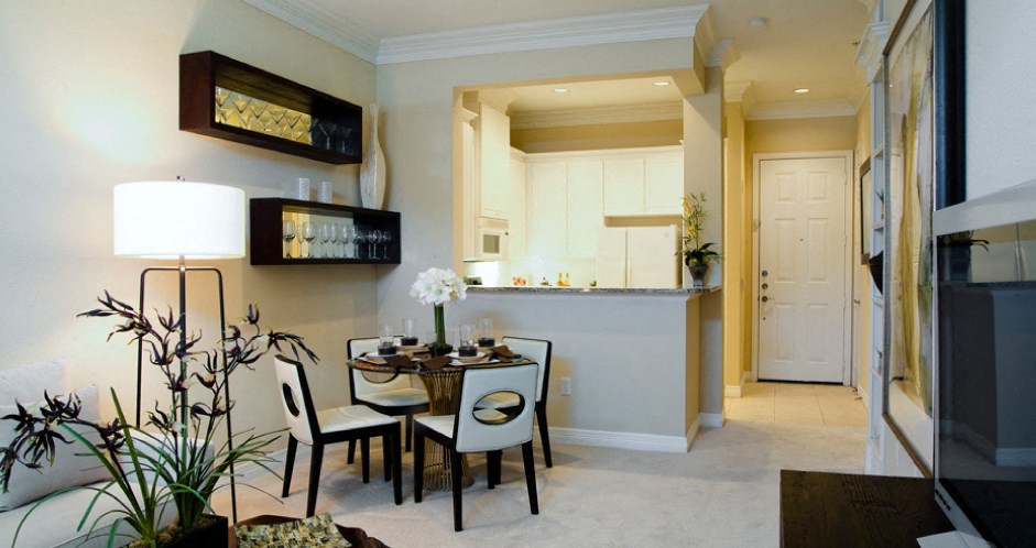 Luxury apartment with spacious dining room, kitchen with granite countertops, white cabinets, and breakfast bar at Tuscany Court Apartments in Houston.