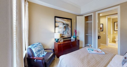 Spacious bedroom with walk-in closet, ceiling fan, and recessed ceiling at Tuscany Court Apartments in Houston.