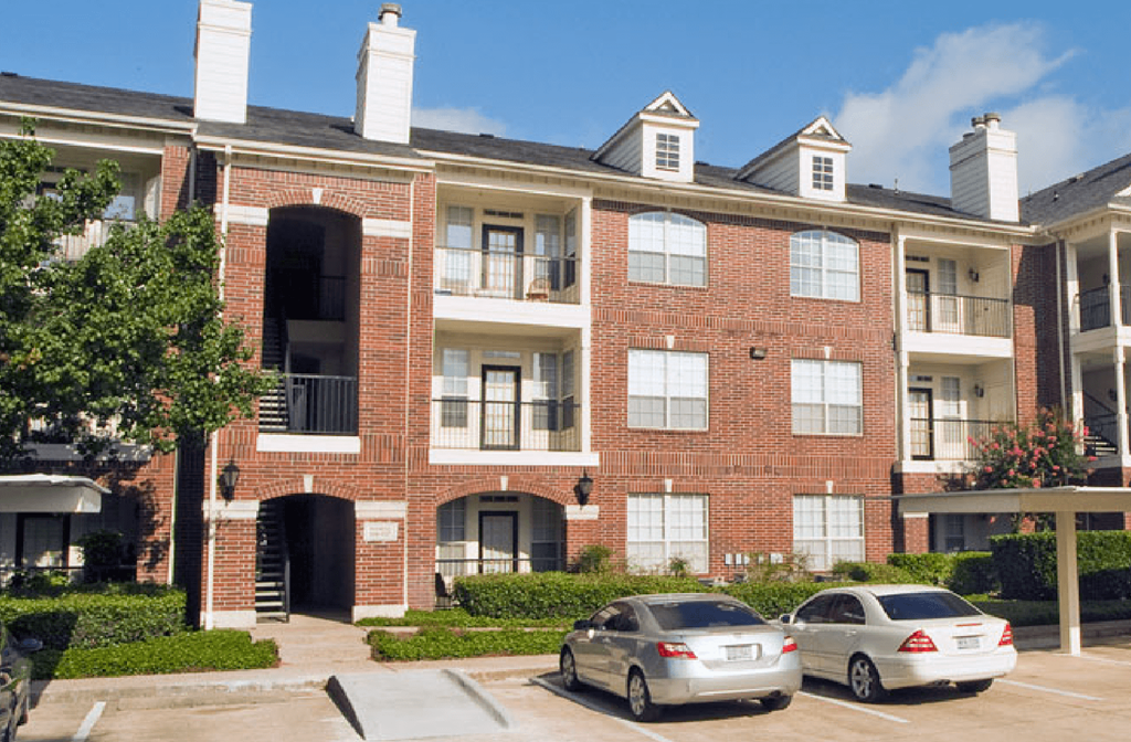 Luxury apartments in a gated community with red brick exteriors at Tuscany Park Apartments in Houston.
