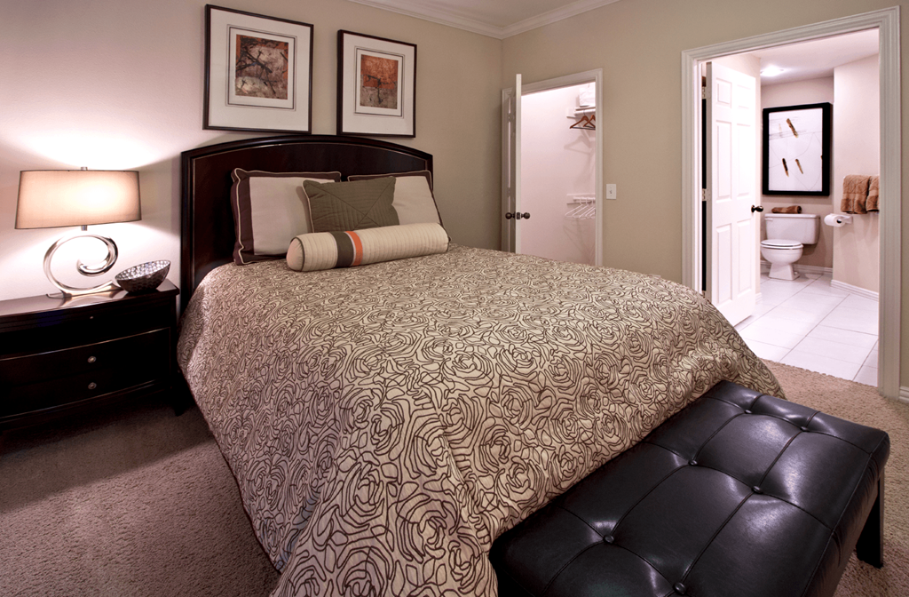 Spacious bedroom with walk-in closet and ceiling fan at Tuscany Park Apartments in Houston.