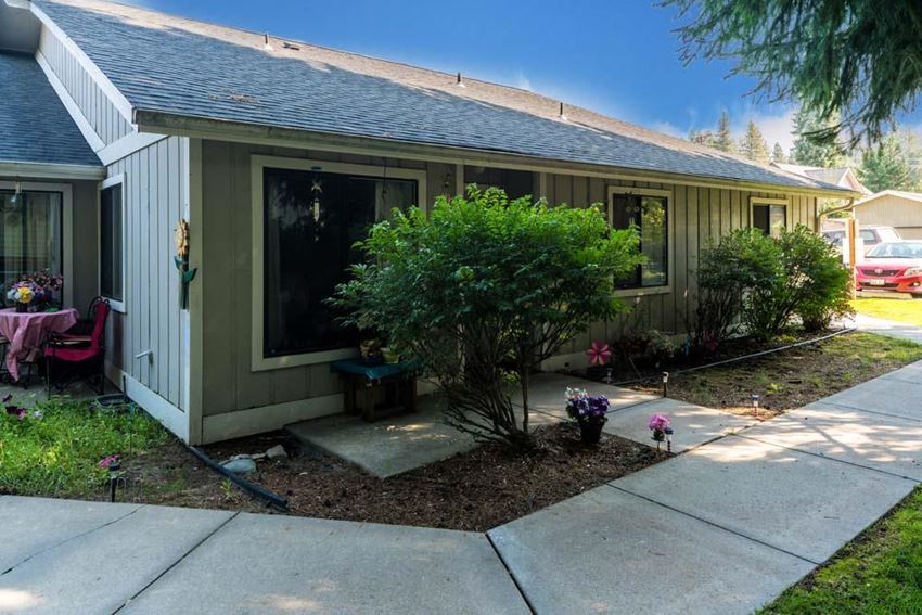 a house with a sidewalk and a tree in the front