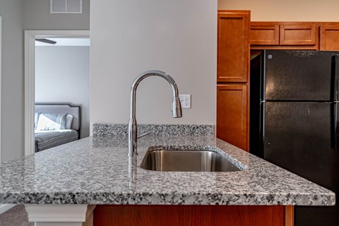 a kitchen with granite counter tops and a stainless steel sink