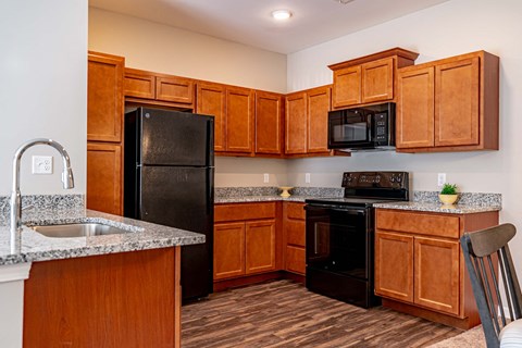 a kitchen with black appliances and wooden cabinets