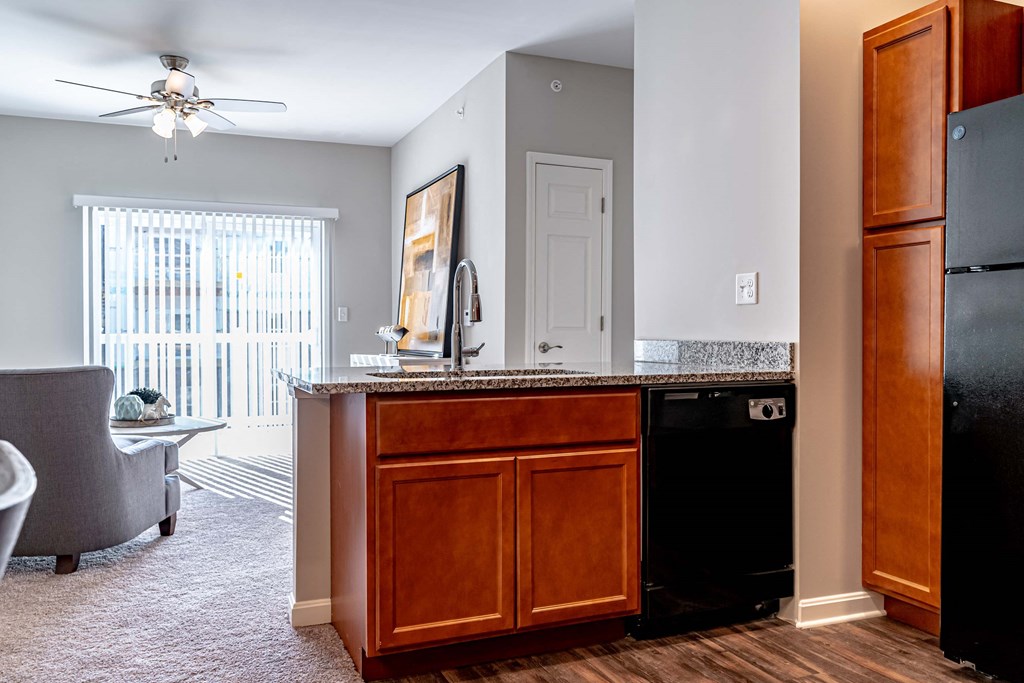 a kitchen with a counter top next to a living room