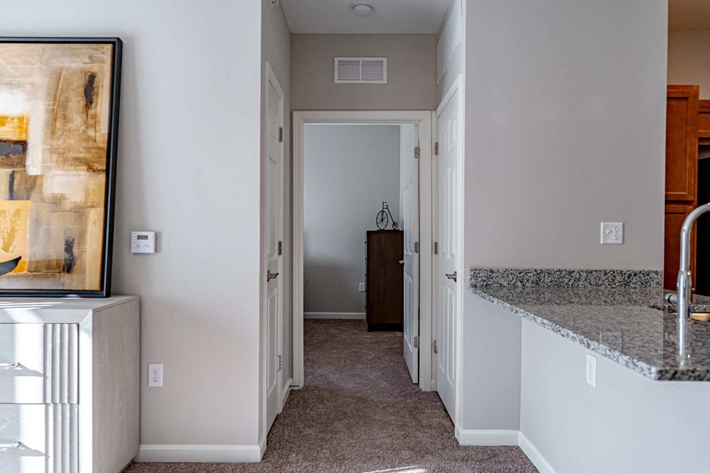 a kitchen with a counter top and a hallway with a door to a bedroom