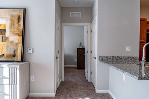 a kitchen with a counter top and a hallway with a door to a bedroom