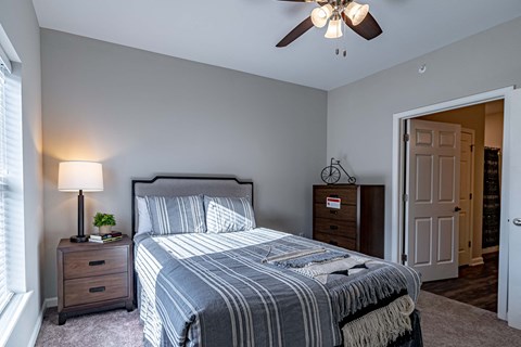 a bedroom with a bed and a ceiling fan