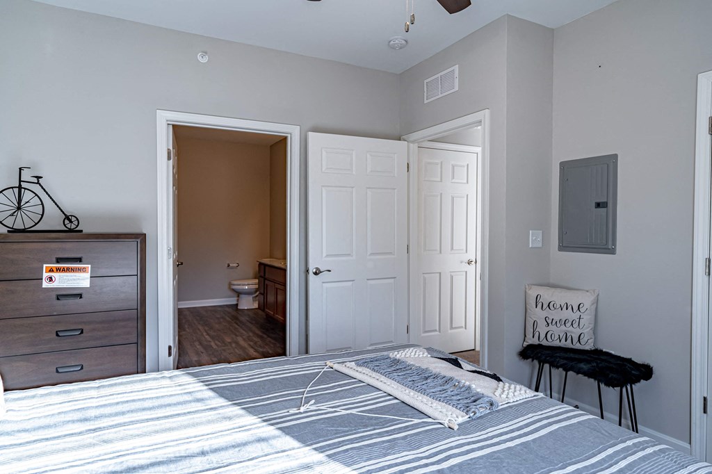a bedroom with a bed and an open door to a bathroom