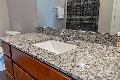 a bathroom with granite counter top and a sink