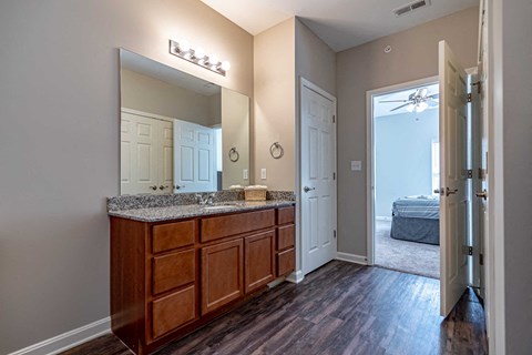 a master bathroom with a large mirror and wooden cabinets