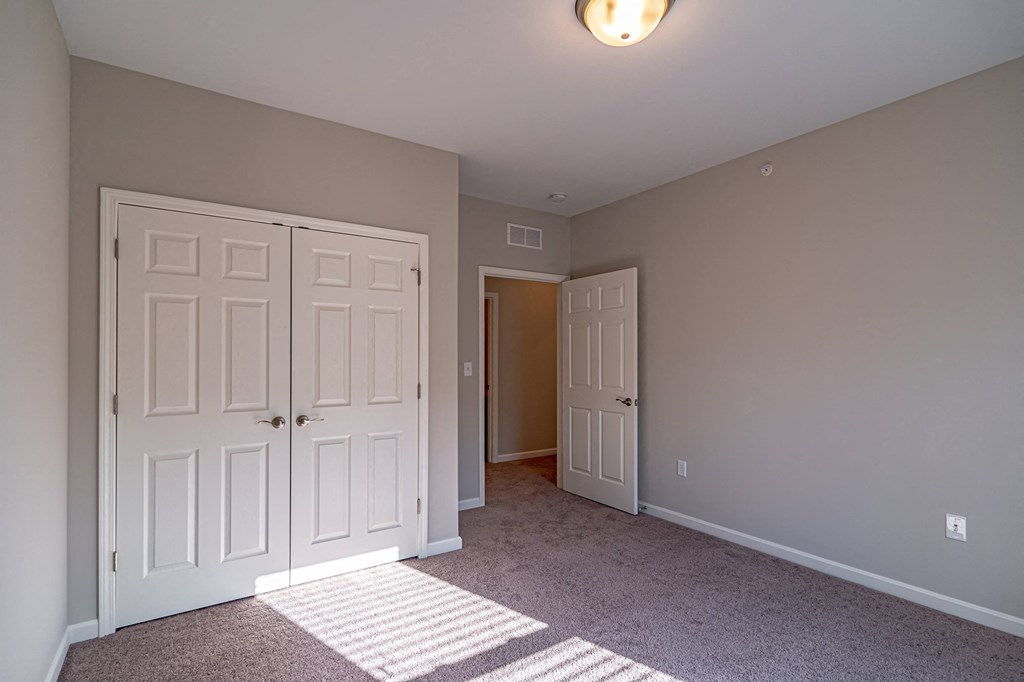 a bedroom with two closets and a door to a hallway