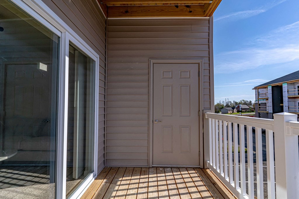 a porch with a white door and a balcony