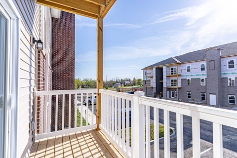 a balcony with a view of a building and a white railing