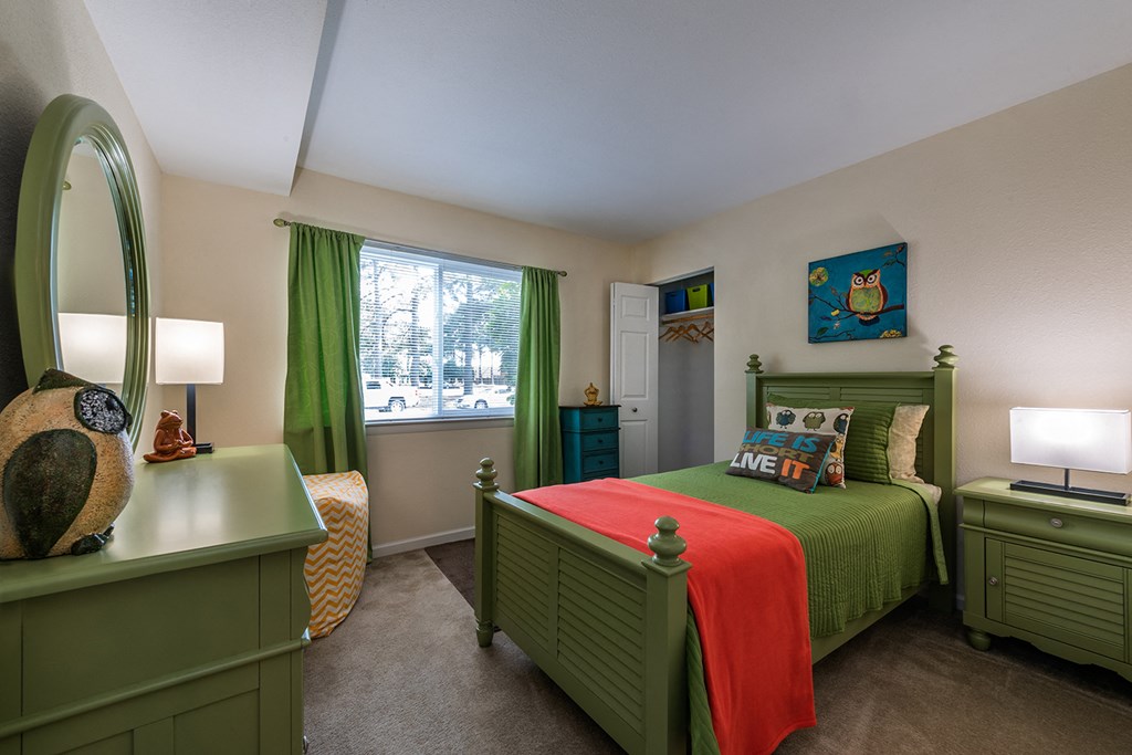 a bedroom with a bed and a dresser and a window