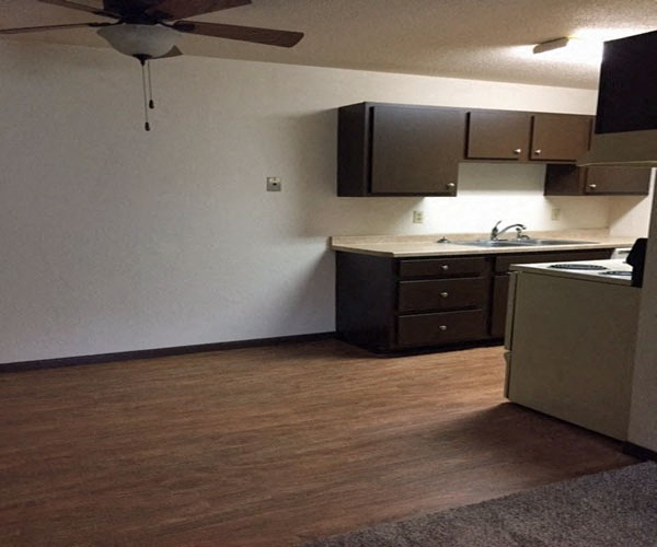 Kitchen with dark cupboards and dining room