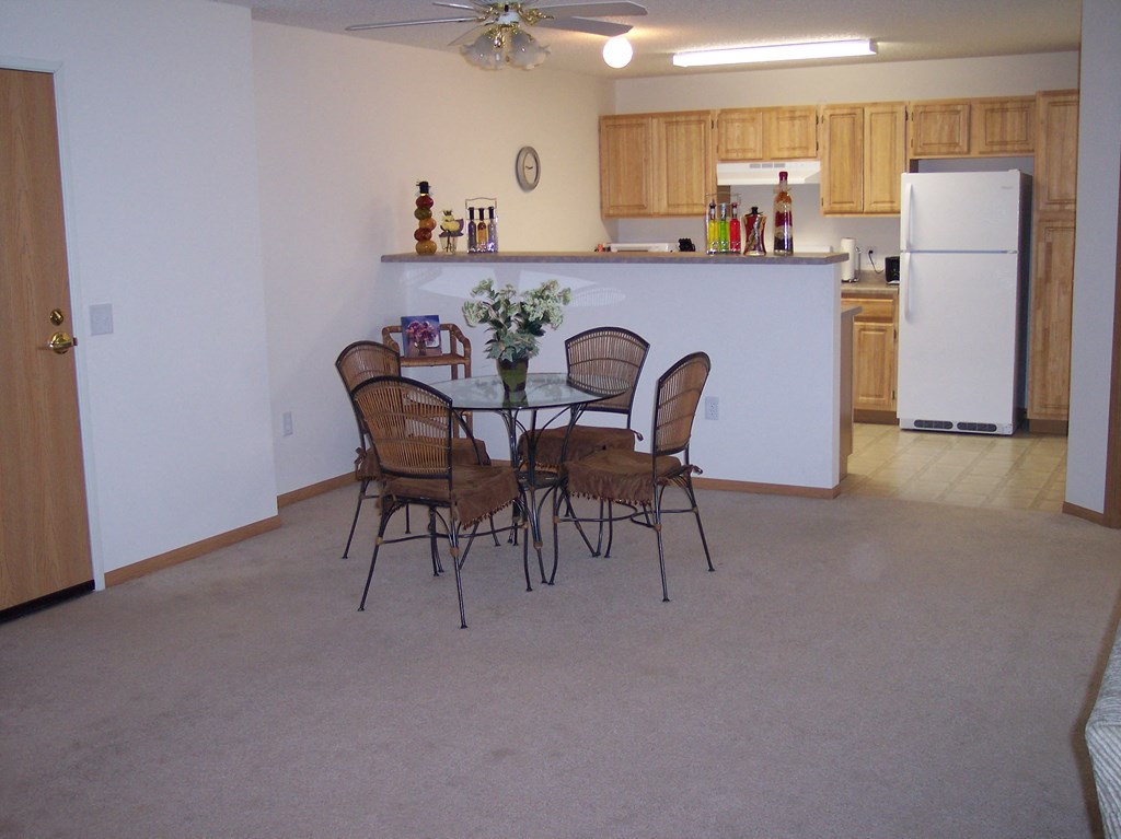 a dining room with a table and chairs and a kitchen