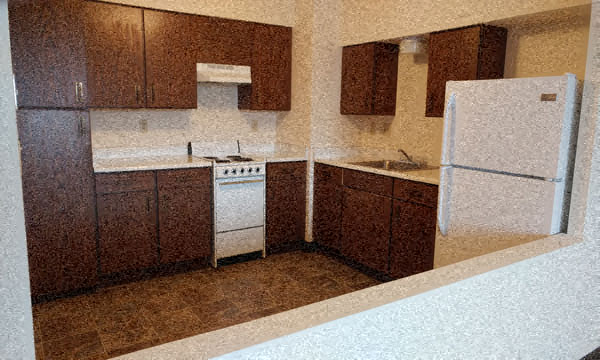 A kitchen with brown cabinets and a white refrigerator.