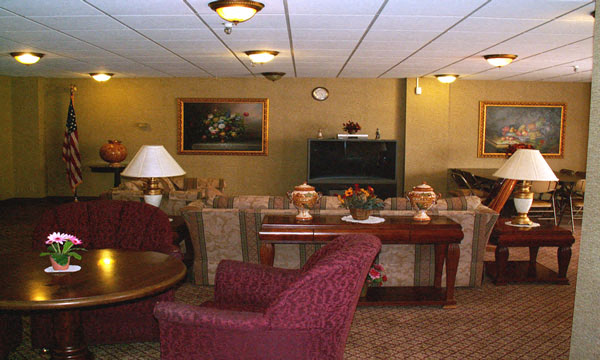 A living room with a red chair and a brown table.