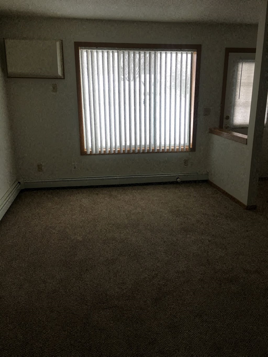 an empty room with a window and a door