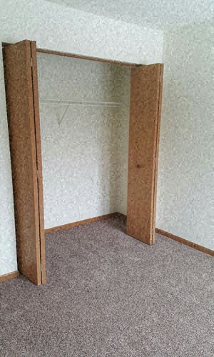 an open closet in a room with carpet