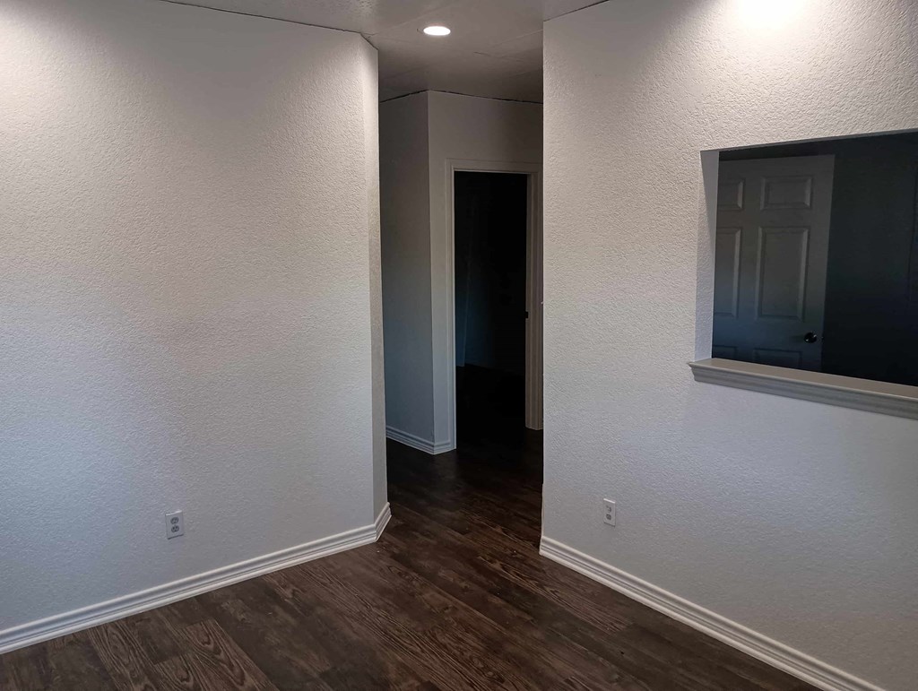 a living room with white walls and wood floors
